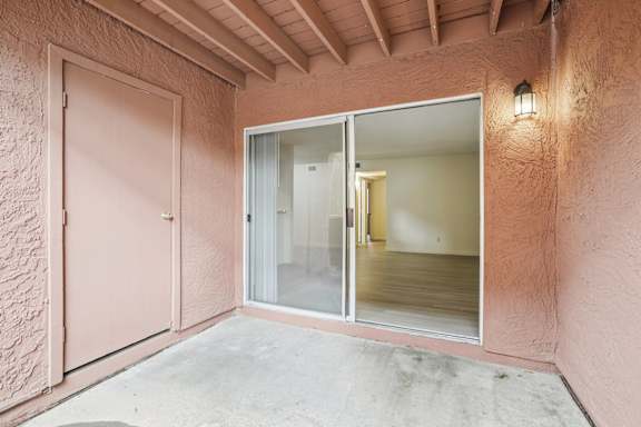 A room with a pink wall and a sliding glass door.