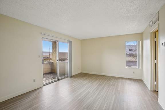 A room with a sliding glass door leading to a balcony.