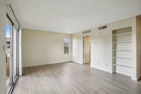 A room with a sliding glass door and a wall-mounted shelf.
