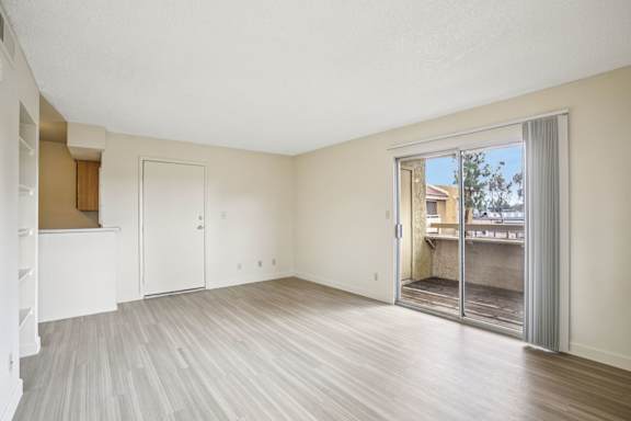 A room with a sliding glass door leading to a balcony.
