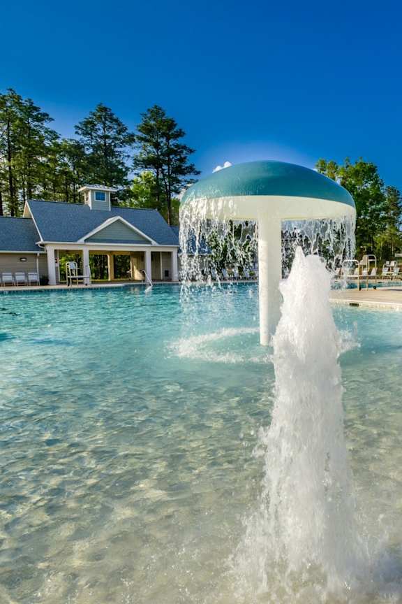 A water fountain in the middle of a pool.