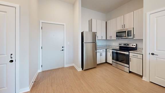 A kitchen with white cabinets and stainless steel appliances.