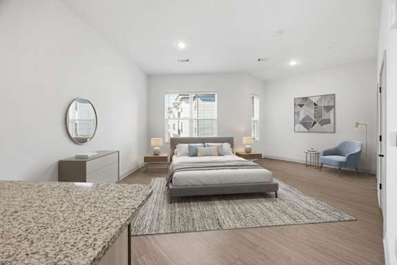 A bedroom with a large bed and a blue chair.