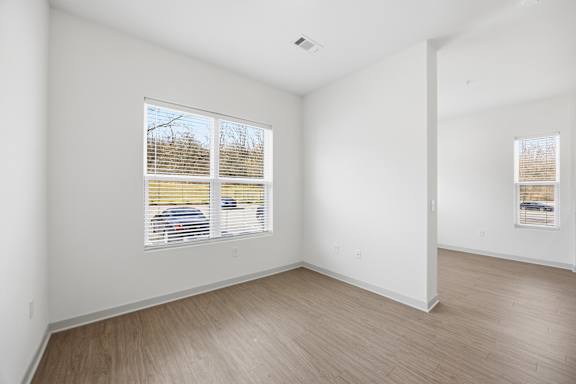 A room with a window and wooden flooring.