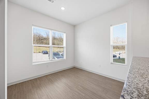 A room with two windows and a car parked outside.