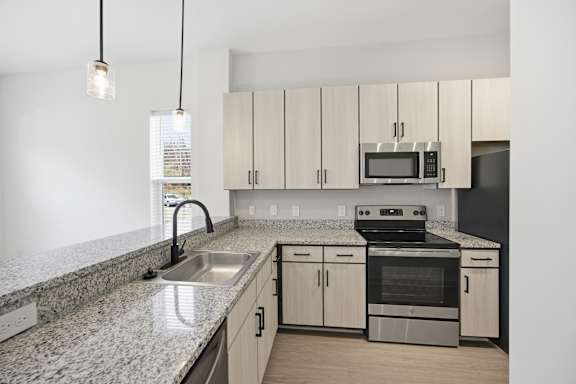 A kitchen with granite countertops and stainless steel appliances.