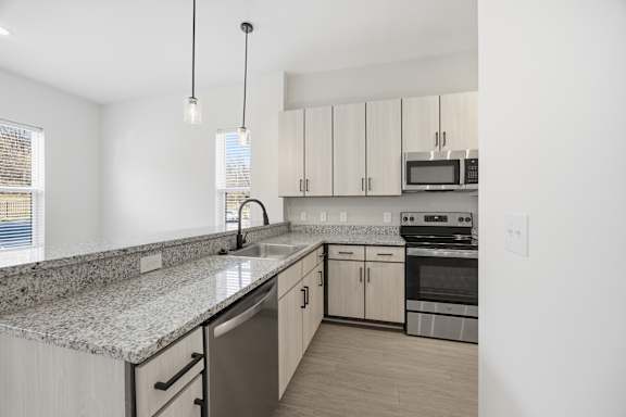 A kitchen with granite countertops and stainless steel appliances.