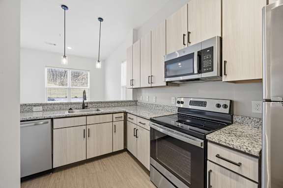 A kitchen with a stove, oven, and refrigerator.