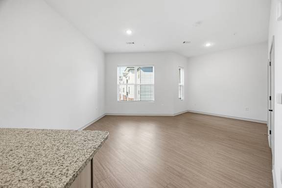 A room with a window showing a building outside.