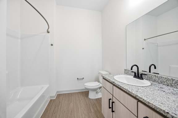 A white bathroom with a sink, toilet, and bathtub.