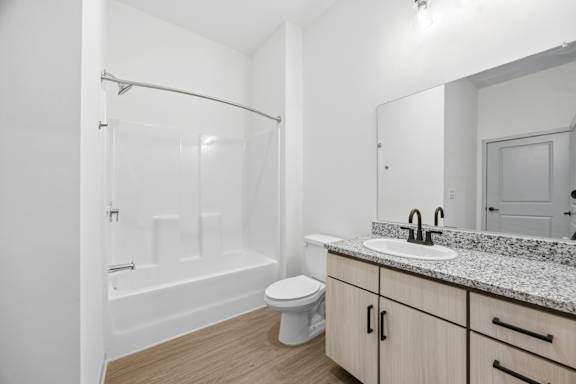 A white bathroom with a toilet, sink, and bathtub.
