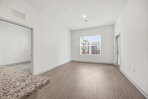 A room with a marble countertop and wooden flooring.