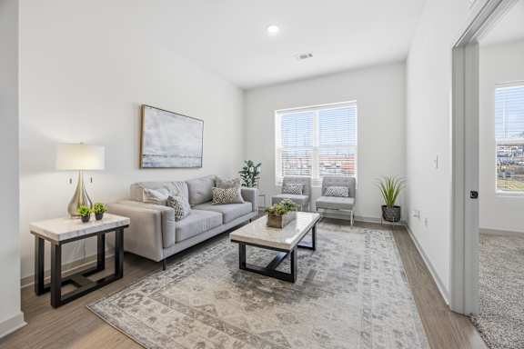 A living room with a grey couch, a coffee table, and a painting on the wall.