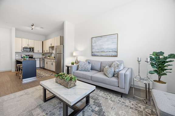 A modern living room with a grey sofa and a coffee table.
