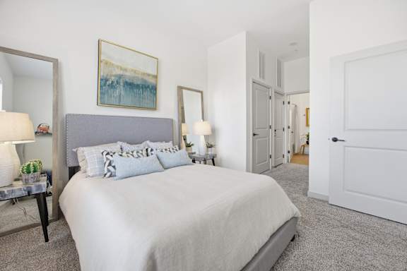 A bedroom with a large bed and a painting on the wall.
