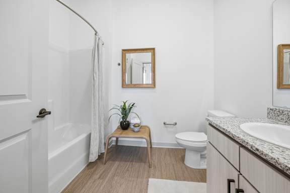 A bathroom with a toilet, sink, and mirror.