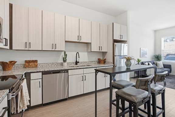 A kitchen with a dining table and chairs.