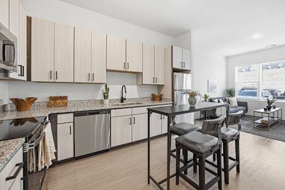 A modern kitchen with wooden cabinets and a black countertop.