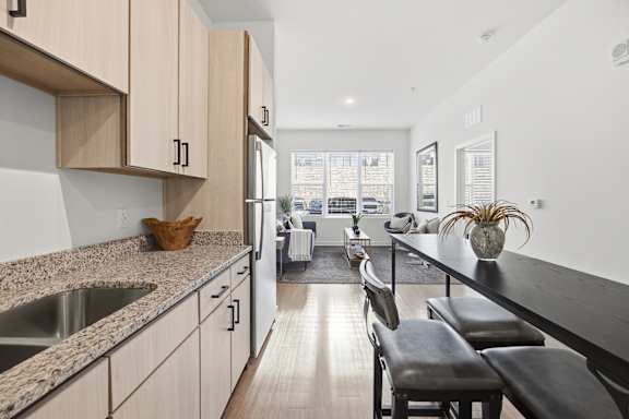 A kitchen with a counter and chairs.
