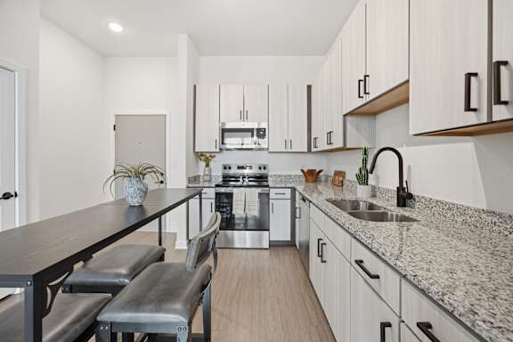 A modern kitchen with a long island and stainless steel appliances.