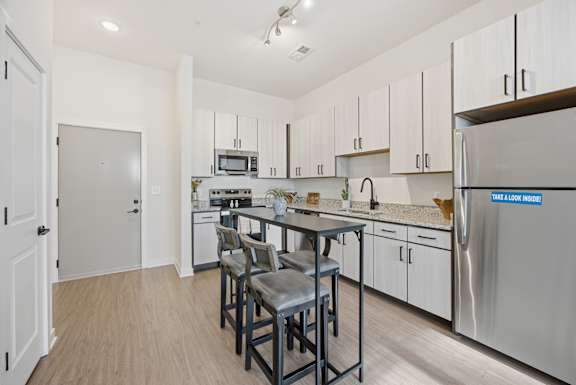A kitchen with a table and chairs in the middle of the room.
