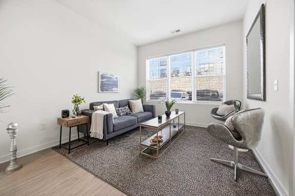 A living room with a grey couch, a coffee table, and a chair.