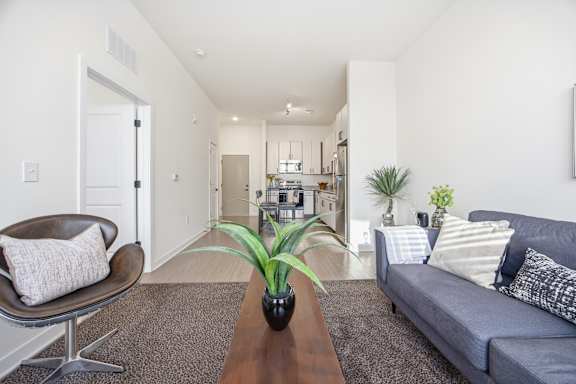 A living room with a grey couch, a brown leather chair, and a wooden coffee table.