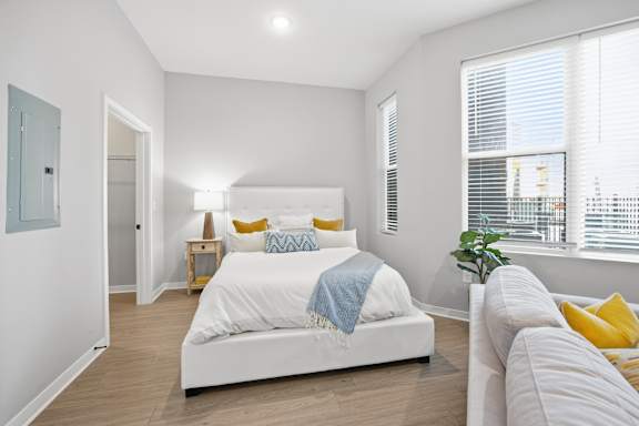A bedroom with a white bed and a blue blanket.