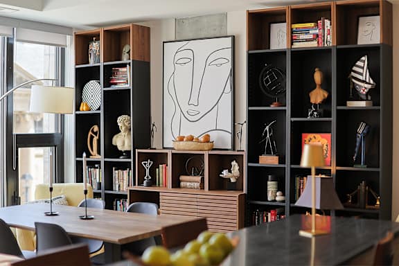 A black bookshelf with a white drawing of a face on it.