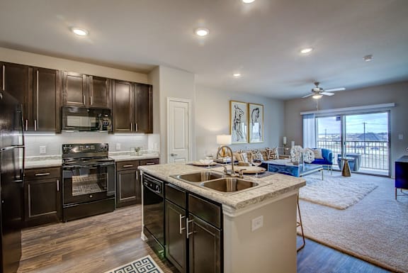 A modern kitchen with dark wood cabinets and stainless steel appliances.