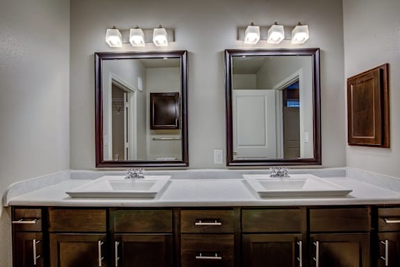 A bathroom with two sinks and a large mirror above them.