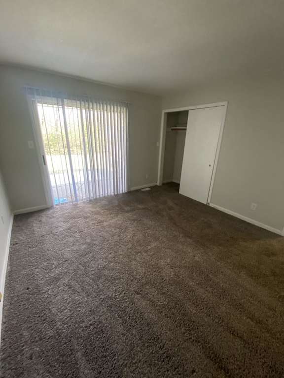 an empty living room with a door to a closet