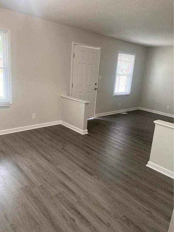 an empty living room with wooden floors and a white door