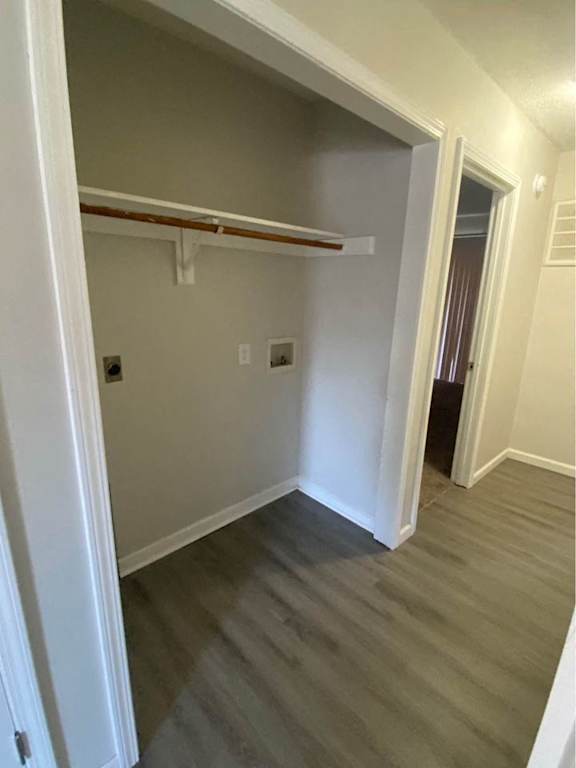 a hallway with wood floors and a closet