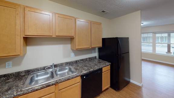 a kitchen with granite counter tops and a black refrigerator