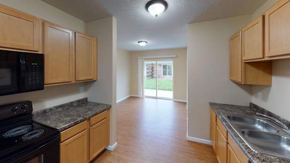 an empty kitchen with wood cabinets and stainless steel appliances