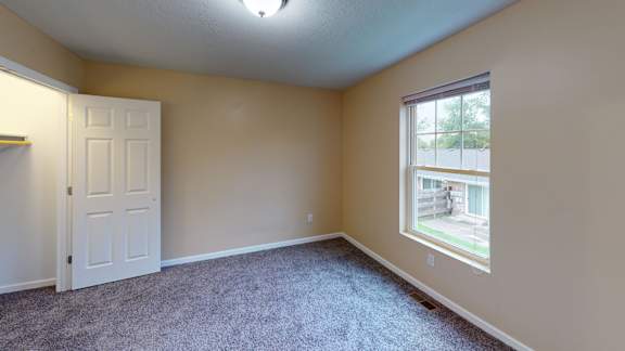 an empty room with carpet and a window