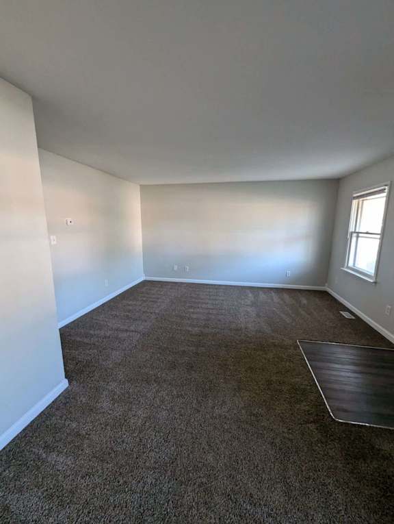 a empty room with a carpeted floor and a window