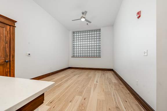 A room with a wooden floor and a ceiling fan.