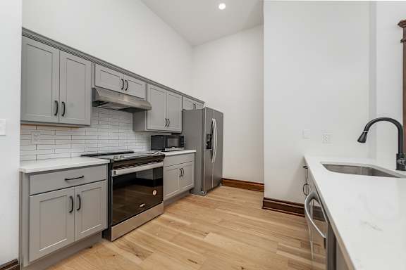A kitchen with wooden floors and white walls.