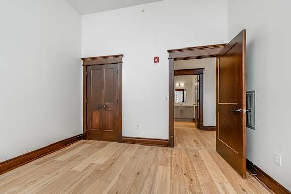 A room with a wooden floor and a wooden door.