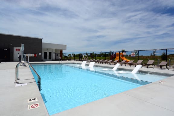 aSwimming pool with chairs at The Landing Apartments, Avon, Indiana