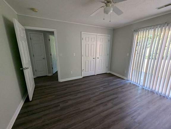 a living room with wood floors and a ceiling fan