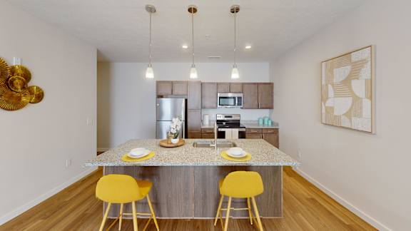 A kitchen with a table and yellow chairs.