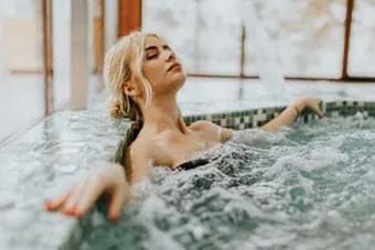 Woman is relaxing in a hot tub at Citizen on Jasper, Edmonton, T5K 0M5