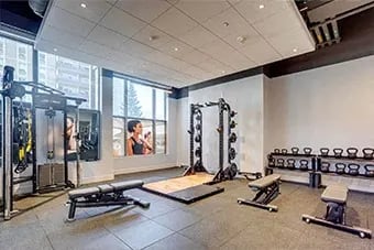 Gym with variety of equipment including a bench at Citizen on Jasper, Edmonton, AB