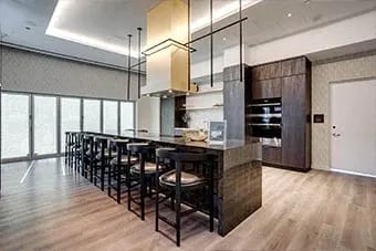 Modern kitchen with a long bar and black chairs at Citizen on Jasper, Edmonton, Alberta