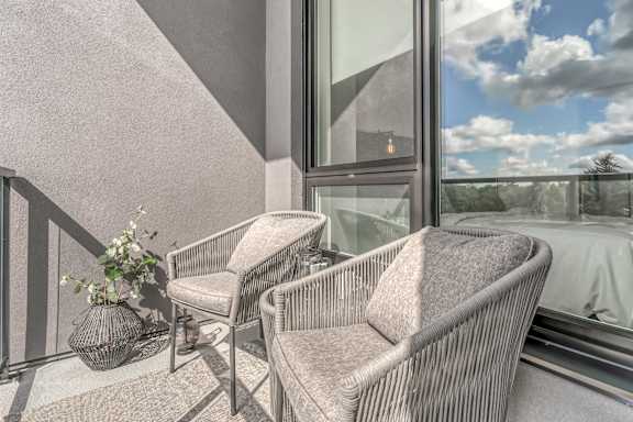 Two chairs and a table on a balcony at Southpark on Whyte, Edmonton, AB