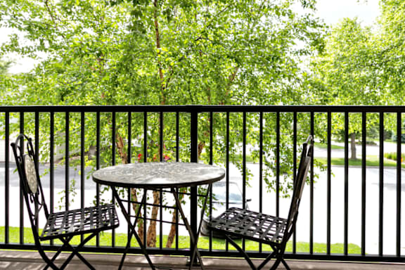 A table with two chairs is on a balcony at The Pointe in La Vista, NE