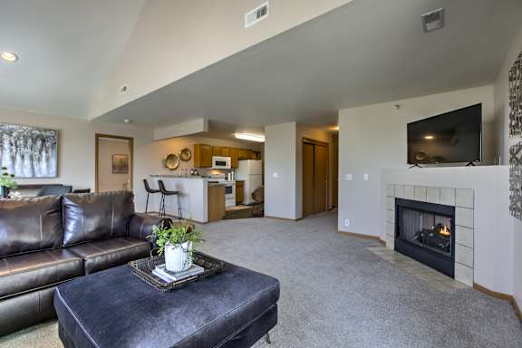 A living room with a fireplace and a couch. at Tranquility Pointe, Omaha, NE